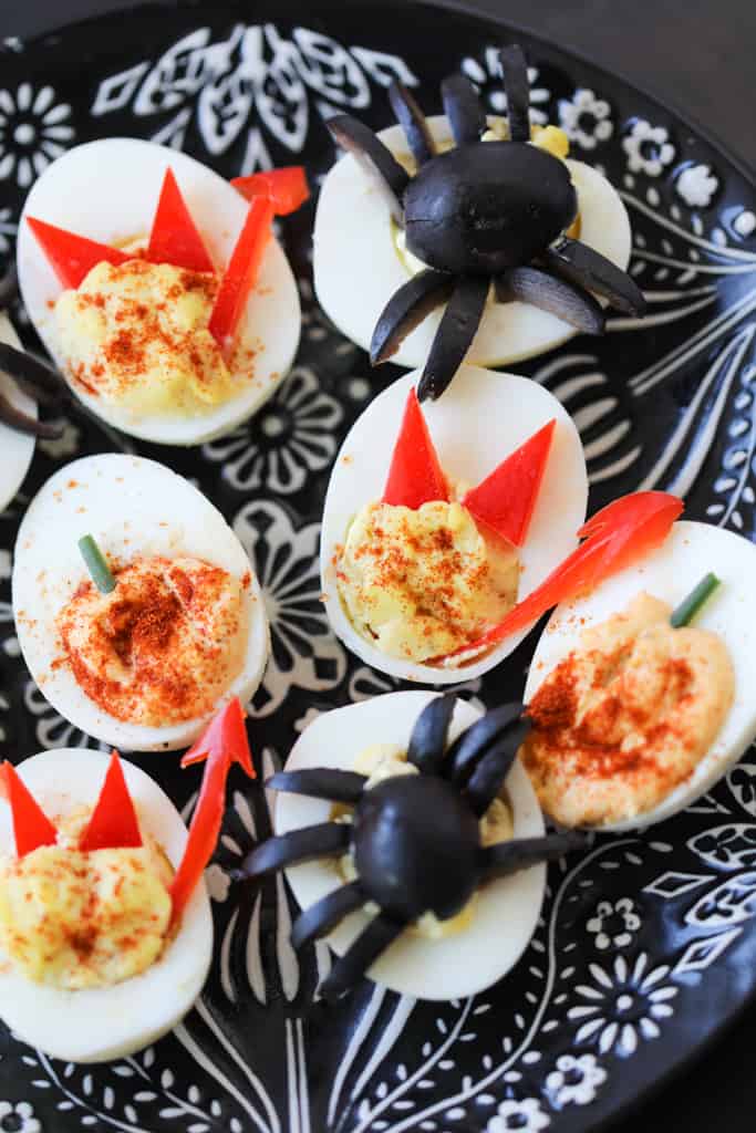 halloween deviled eggs recipe styled on a black plate