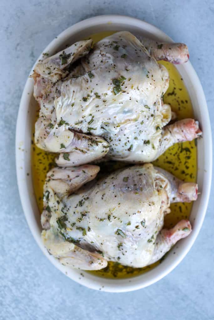 air fryer cornish game hens getting seasoned with butter and fresh herbs before air frying