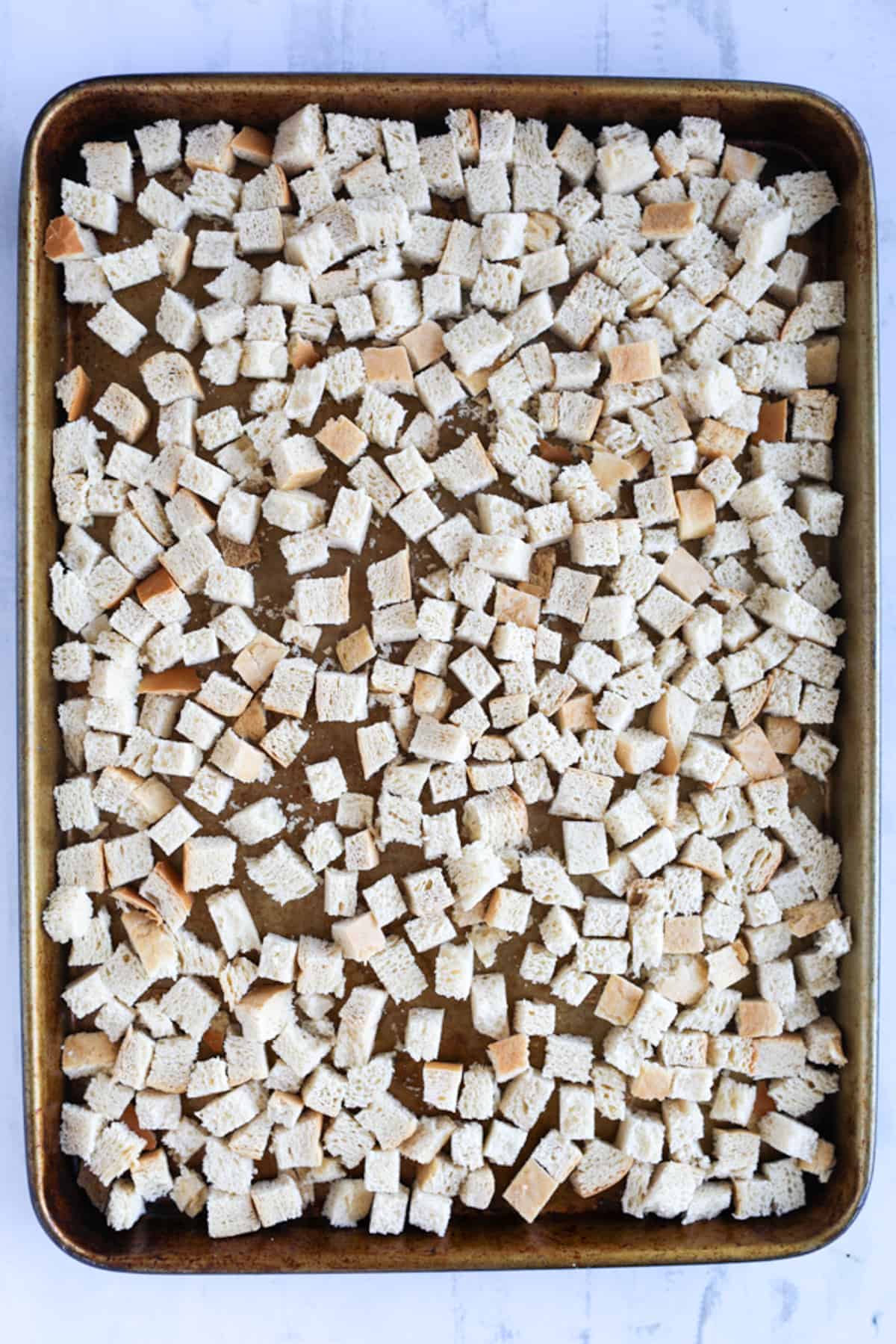 drying out bread for stuffing in the oven on a sheetpan