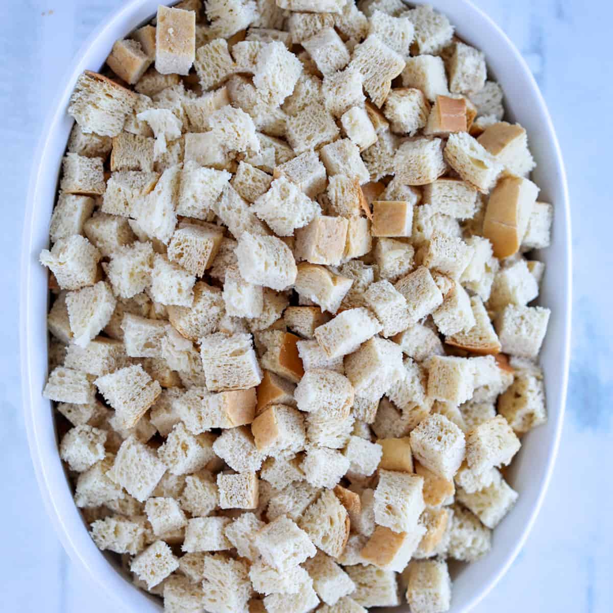 cutting bread cubes into pieces before drying bread in oven