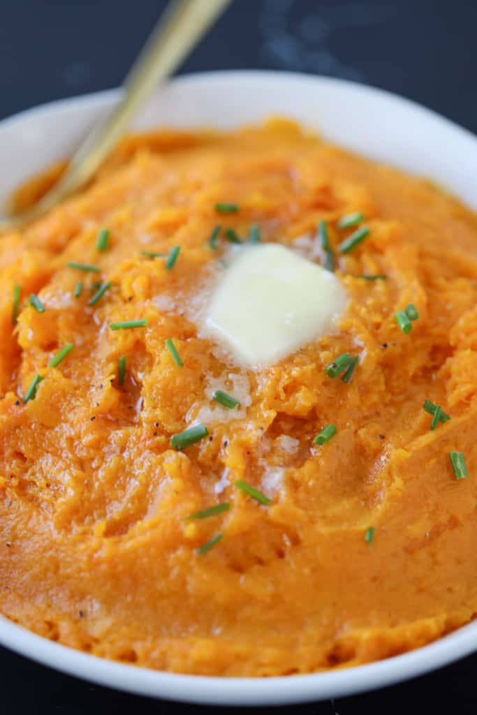 pureed butternut squash in a white bowl with butter