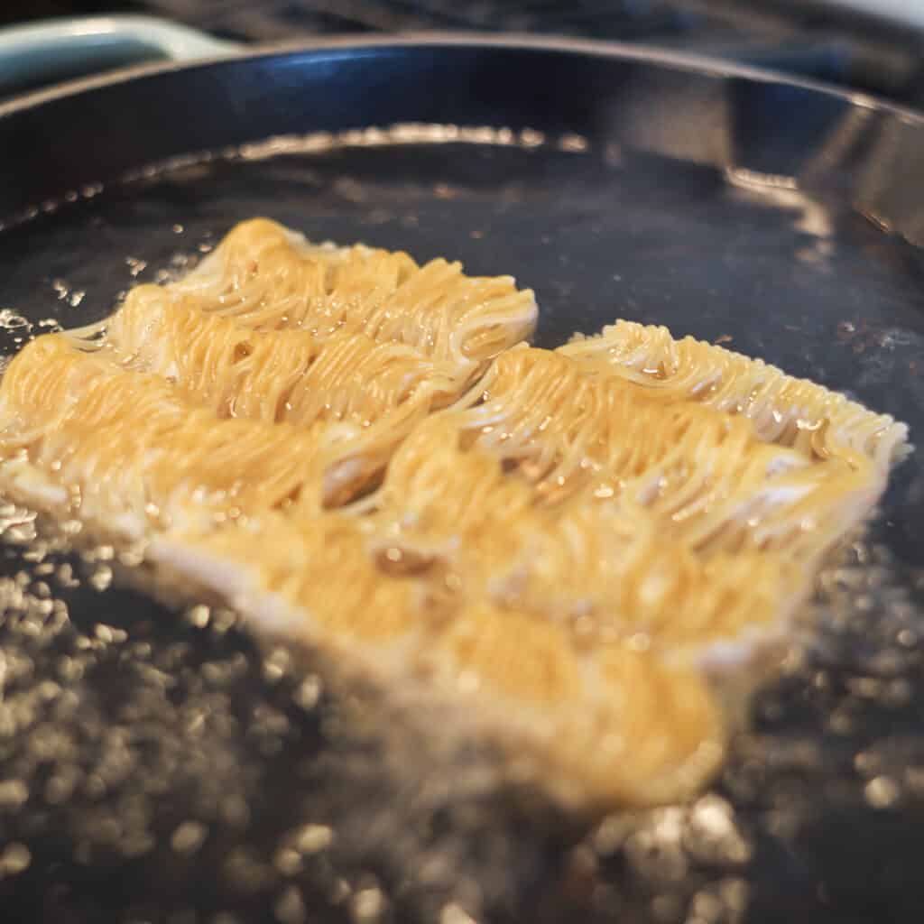 tiktok ramen recipe cooking in a skillet