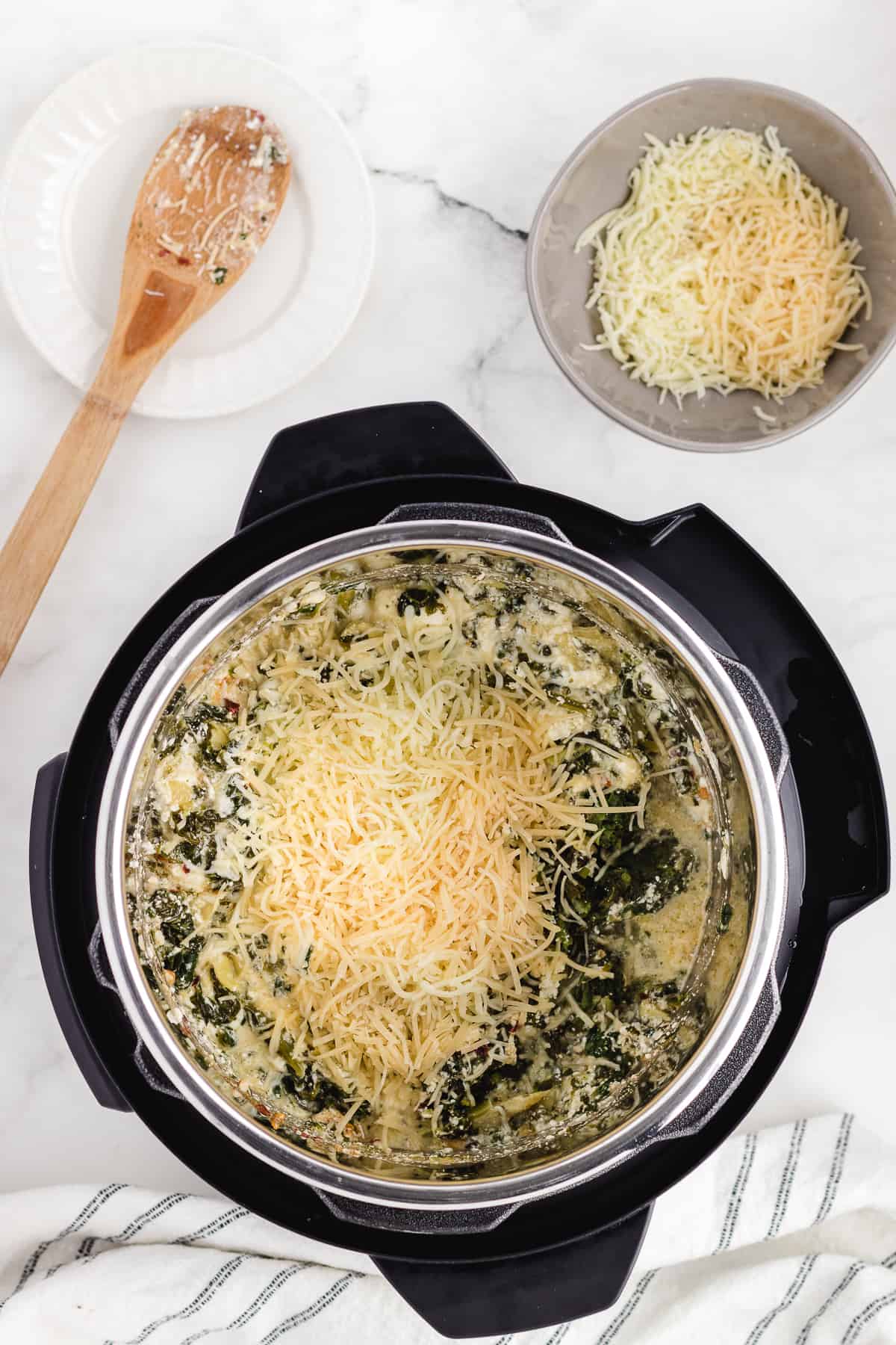 adding cheese to the pot and stir it in