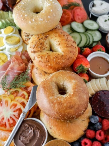 bagel charcuterie board ideas piled up on a wooden cutting board
