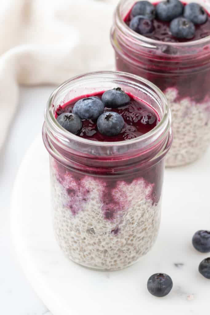 blueberry chia pudding in mason jars on a white background