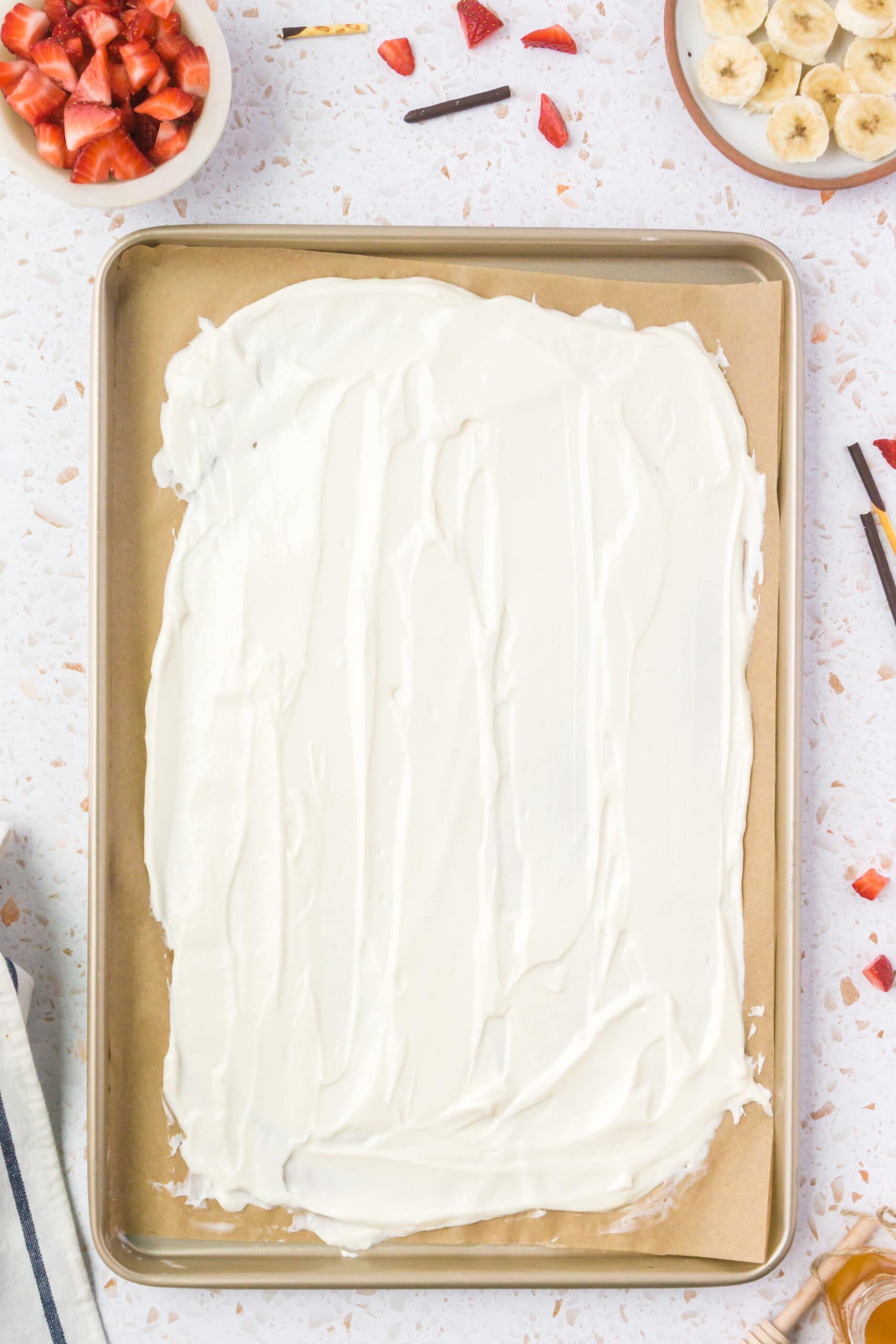 yogurt getting spread on a baking sheet for healthy yogurt bark