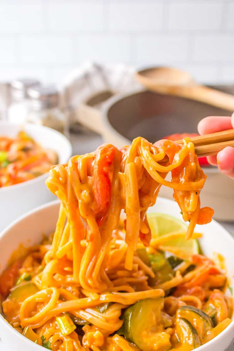 rice noodles with curry sauce on chopsticks