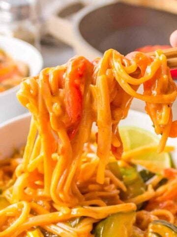 curry rice noodles on chopsticks with Thai flavors and red curry paste