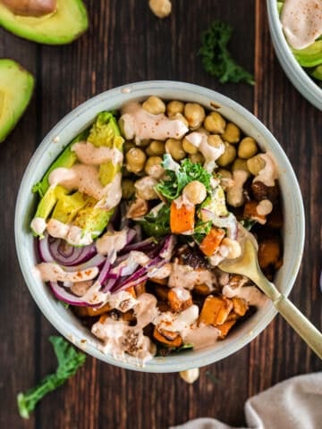vegan buddha bowl with spicy sauce on a wood background