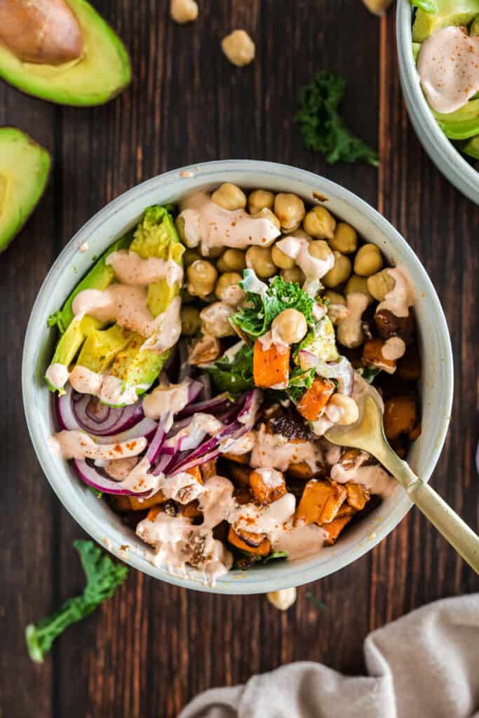 vegan buddha bowl with spicy sauce on a wood background