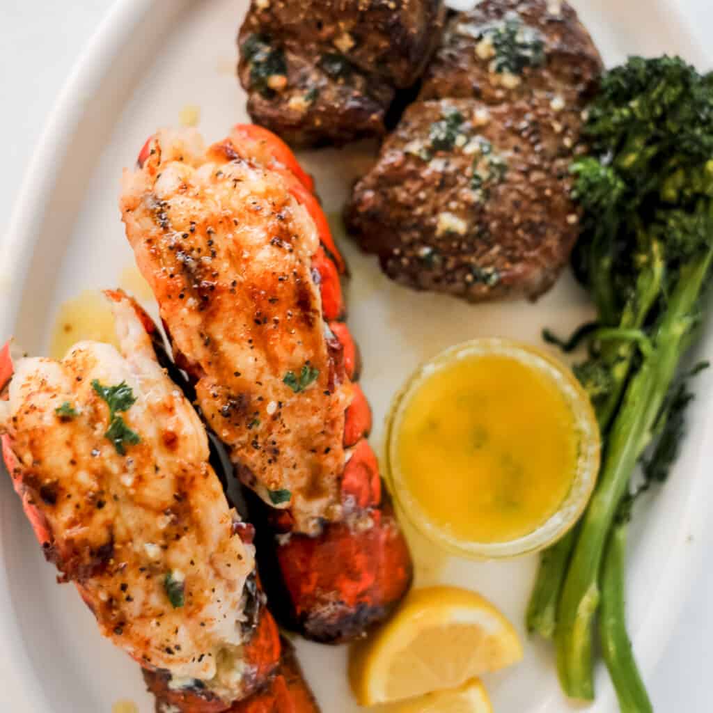 surf and turf dinner on a plate with lemon and compote butter