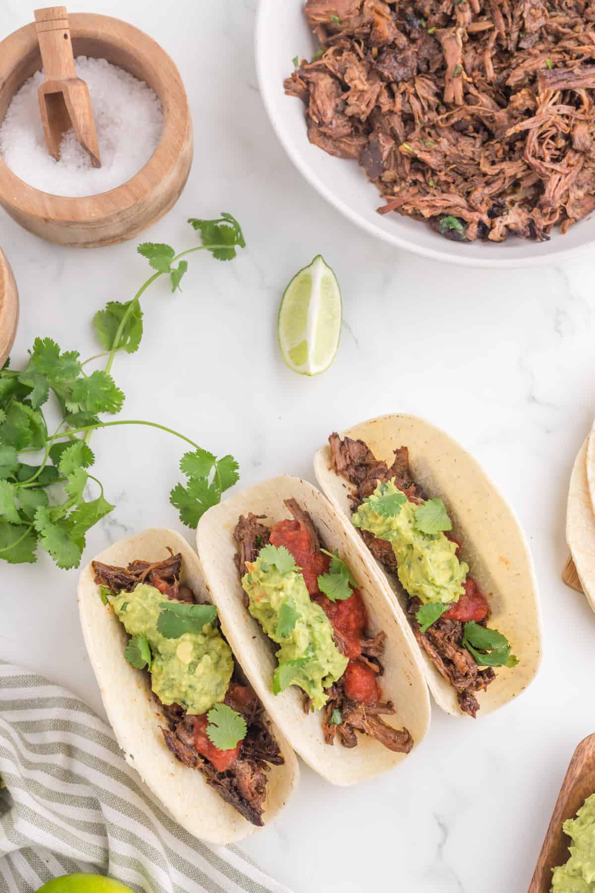 Three tacos filled with beef barbacoa.
