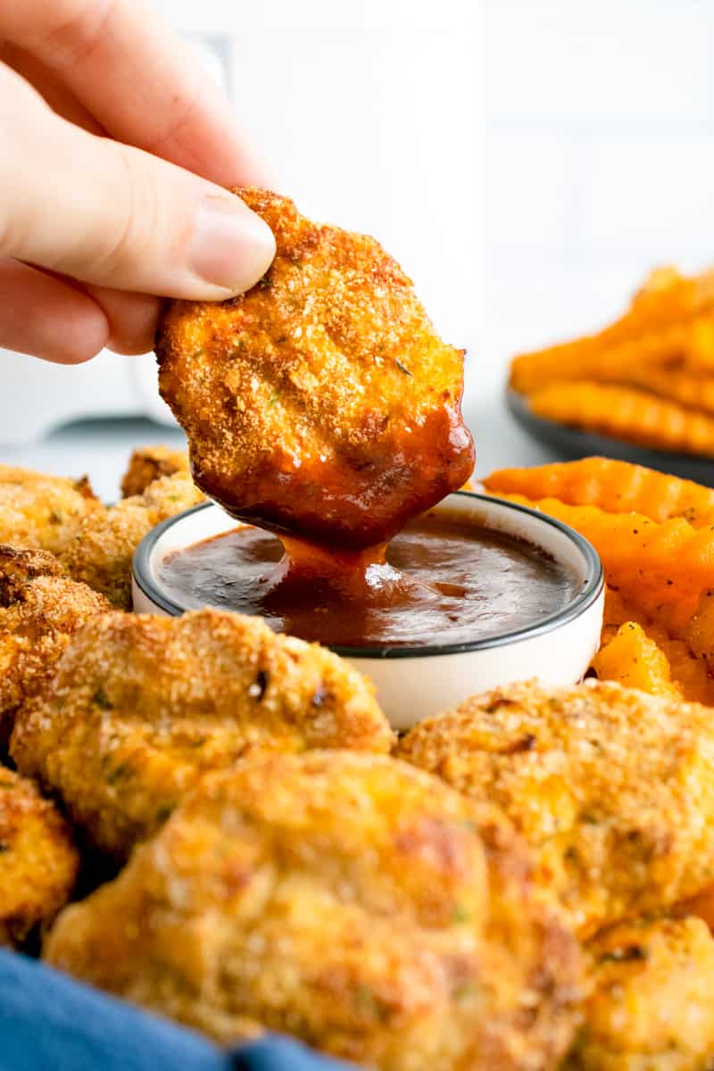 chicken nuggets dipped in bbq sauce.