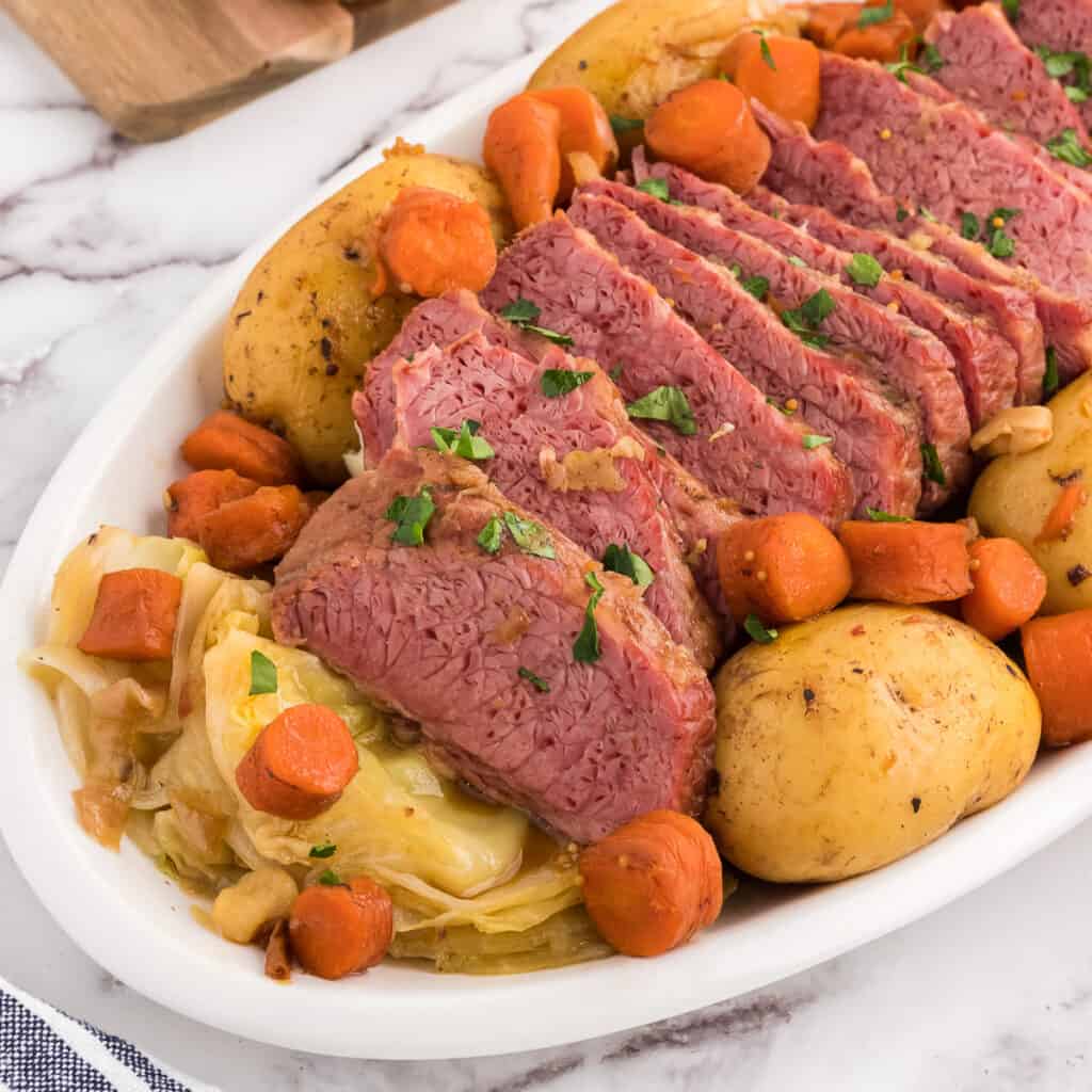 family style platter of baked corned beef and cabbage.