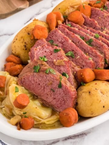 family style platter of baked corned beef and cabbage.