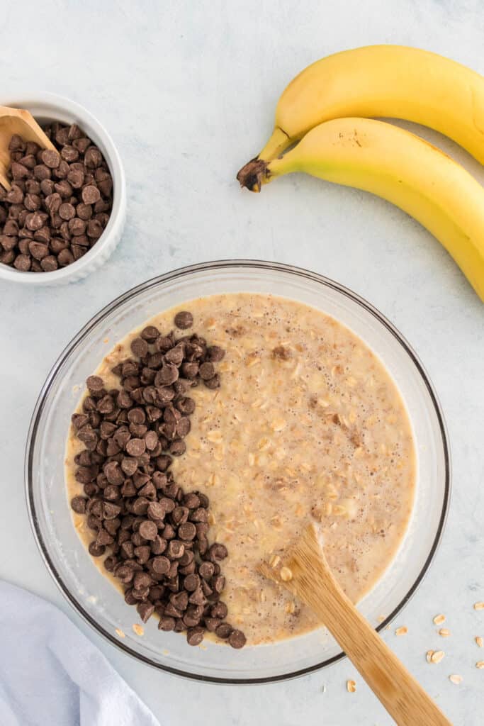 Chocolate chips being added to the oatmeal banana mixture.