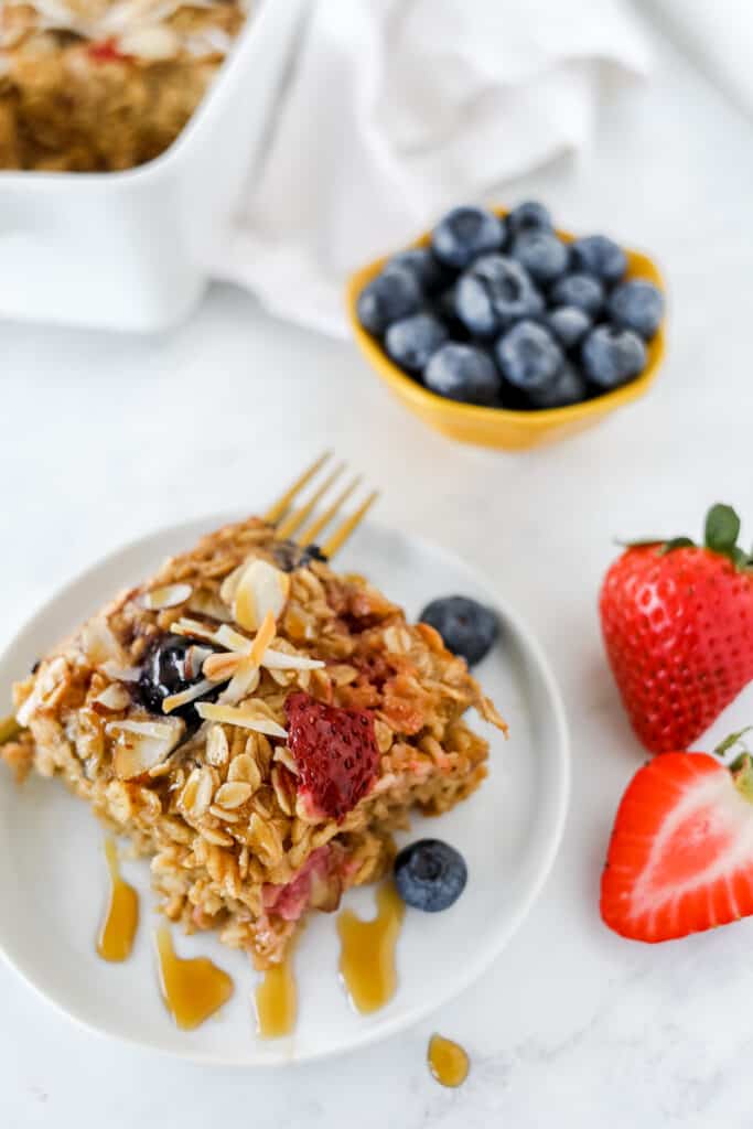 A slice of baked oatmeal with berries on a plate.