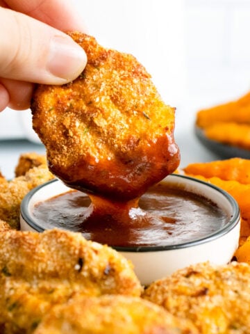 chicken nuggets dipped in bbq sauce.
