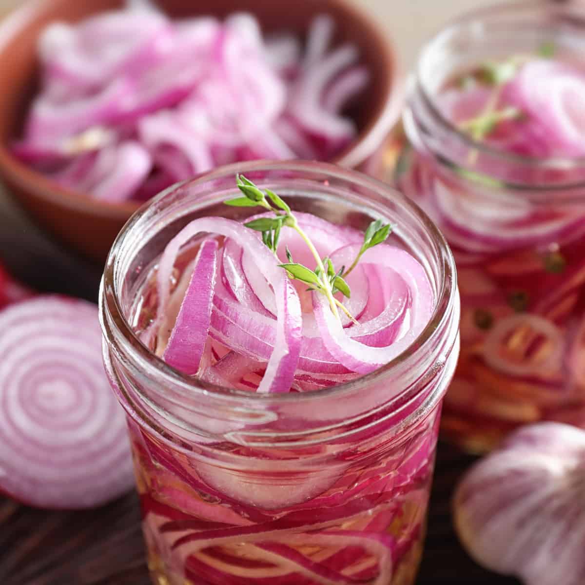 Two jars of pickled red onions before being sealed.