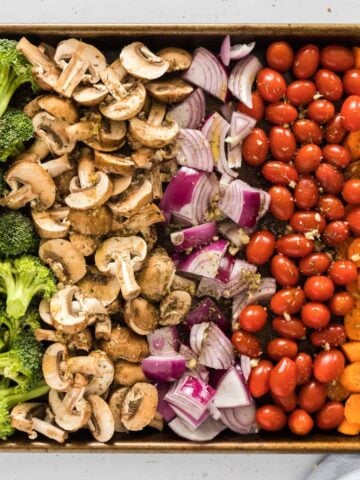 A sheet pan of veggies layered next to eachother.