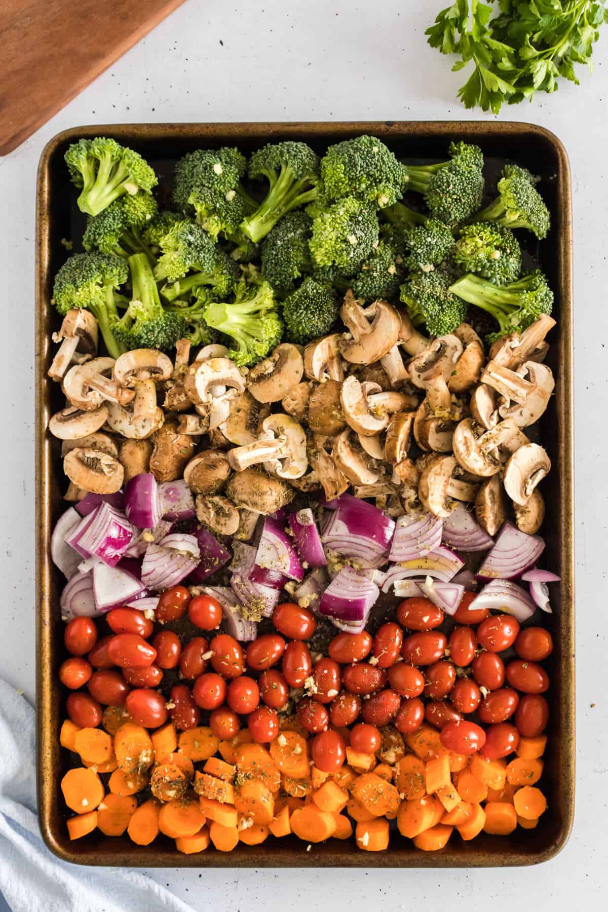 A sheet pan of veggies layered next to eachother.