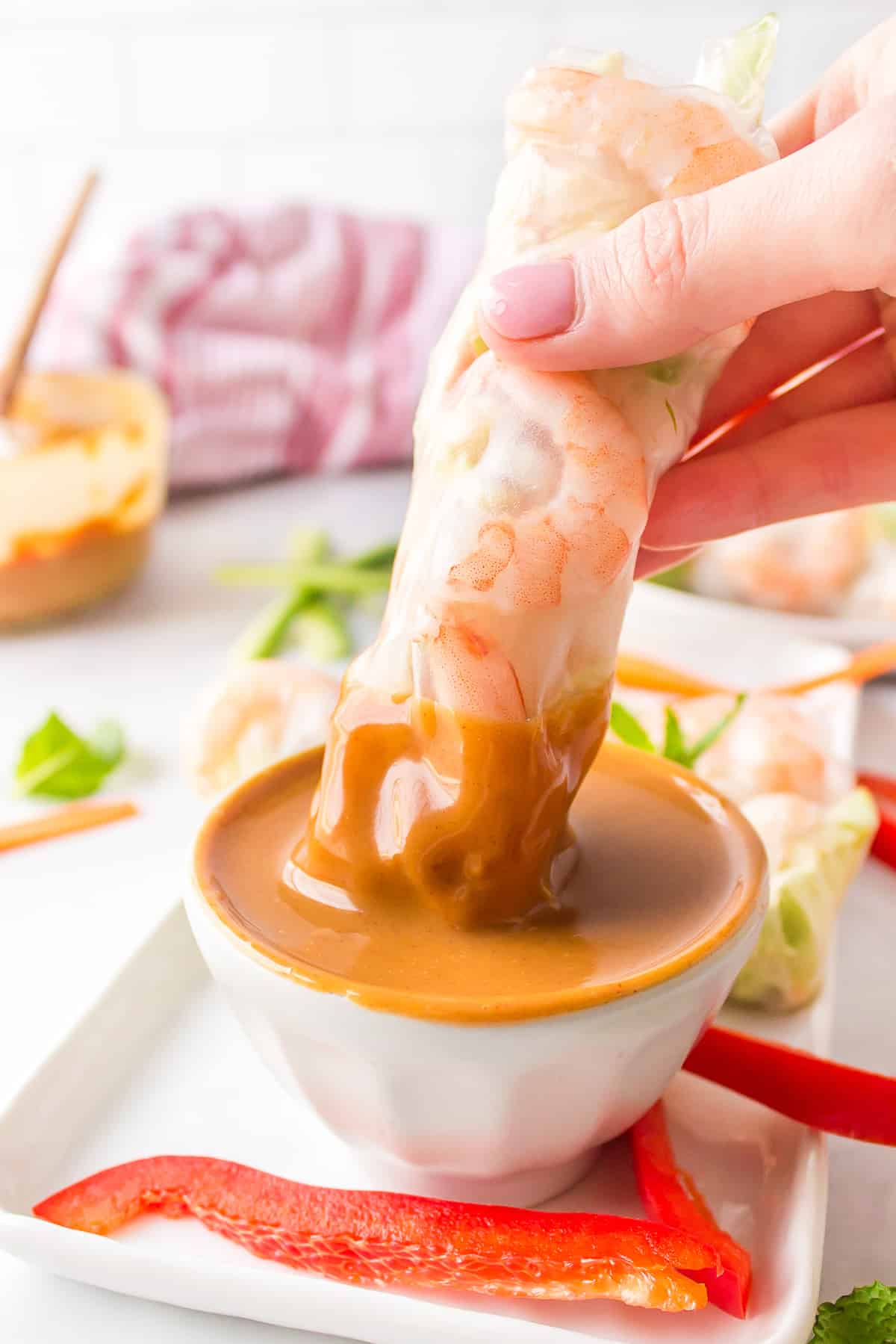 Dipping a shrimp spring roll into peanut sauce.