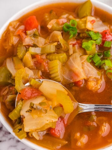 Bowl of detox cabbage soup with a spoon.
