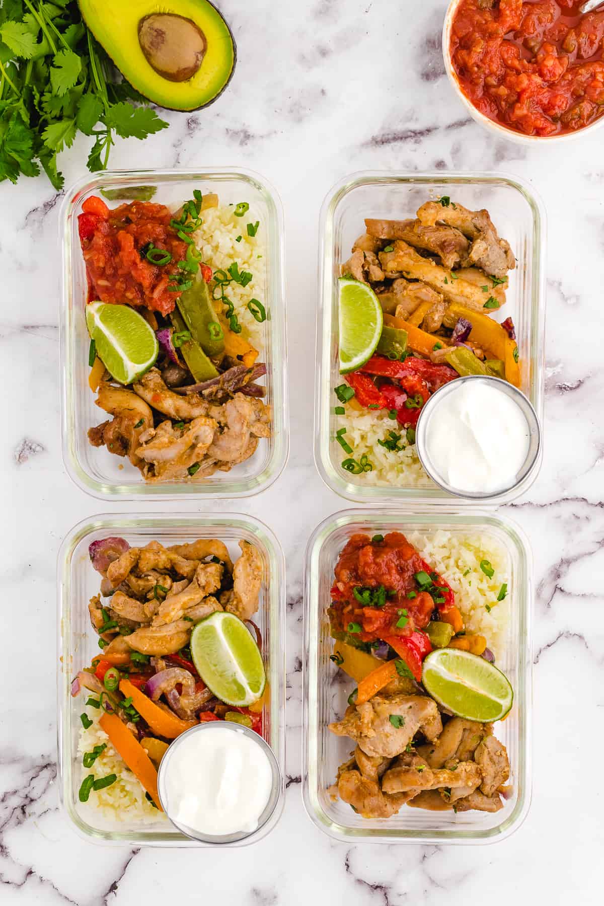 4 meal prep containers with chicken fajitas in them.
