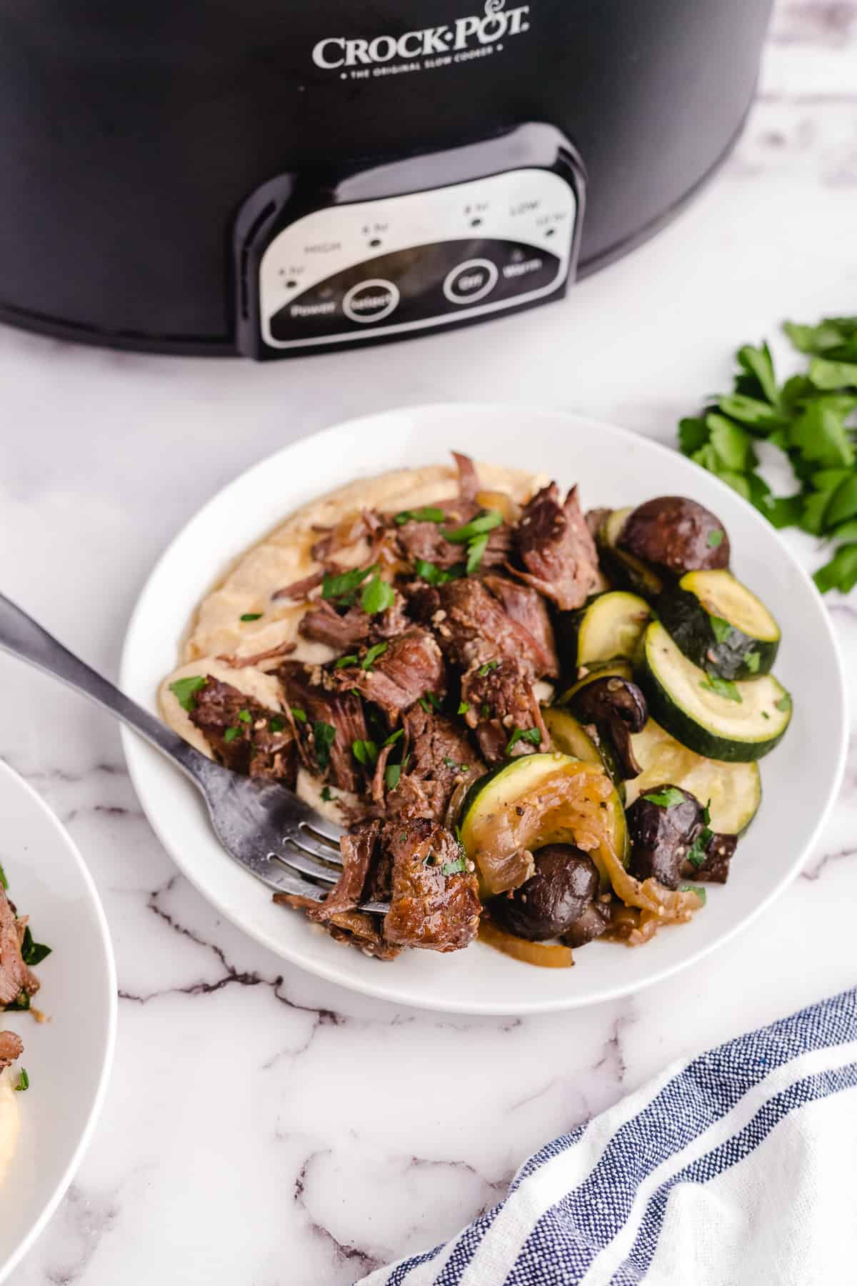 A plate of keto chuck roast served over cheesy mashed cauliflower.