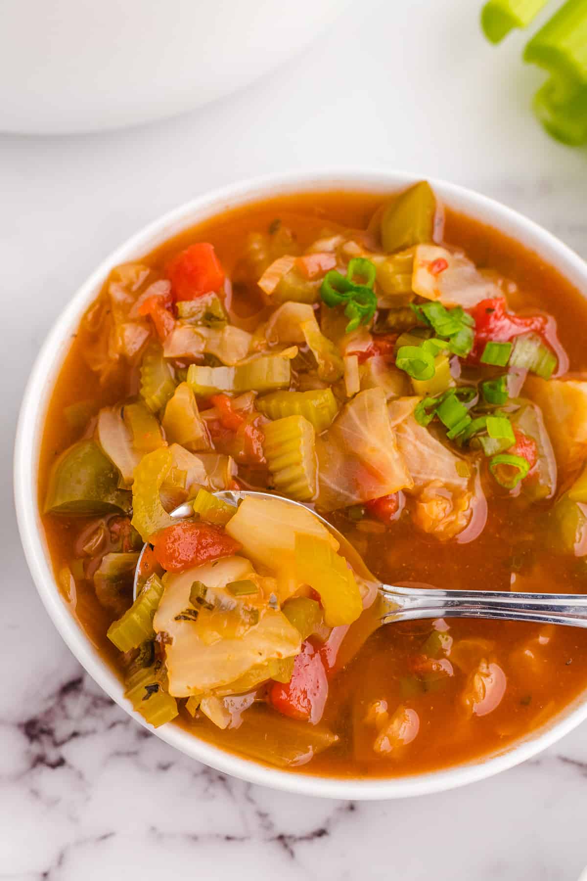 Bowl of detox cabbage soup with a spoon.