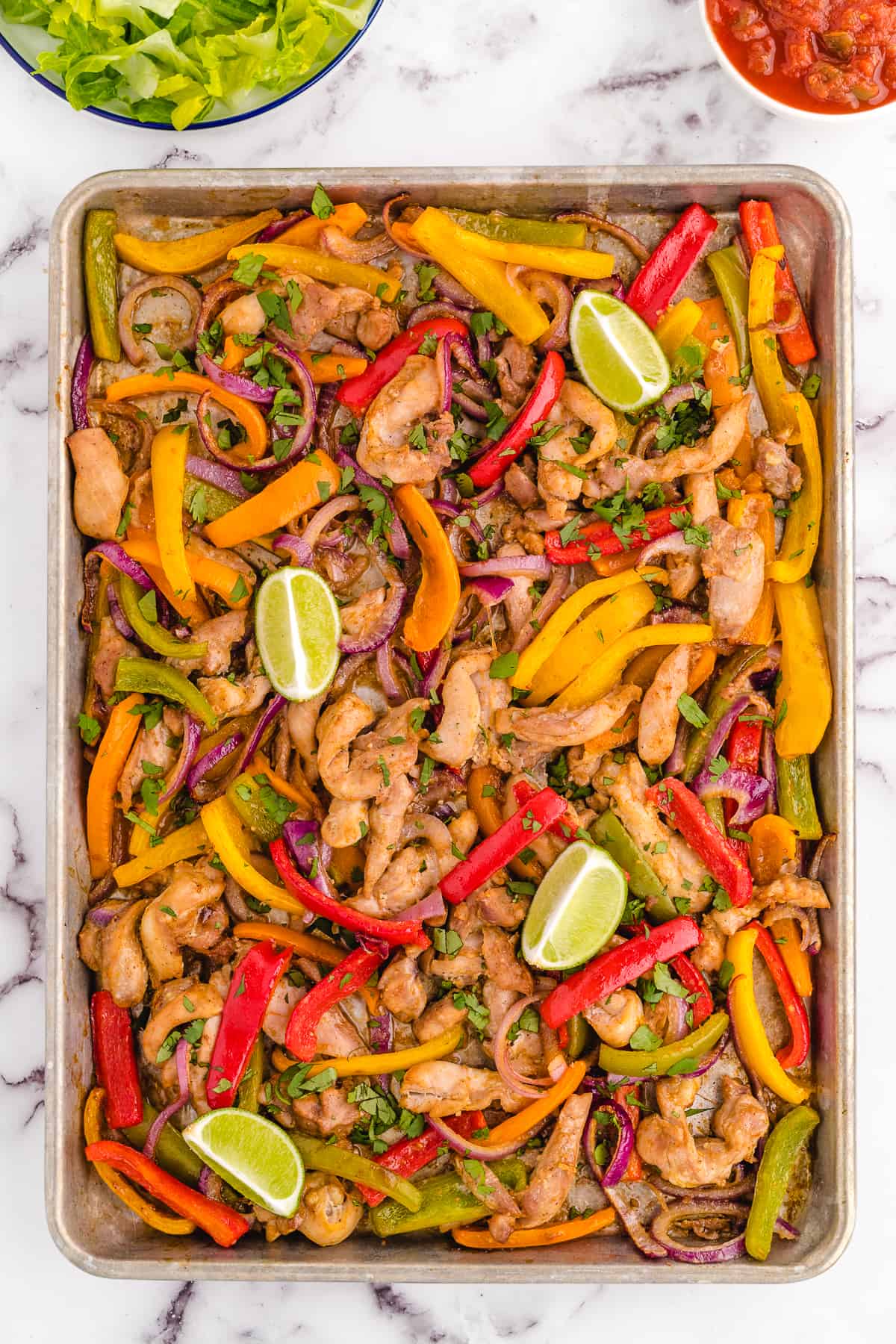 cooked sheet pan fajitas still on the baking sheet.
