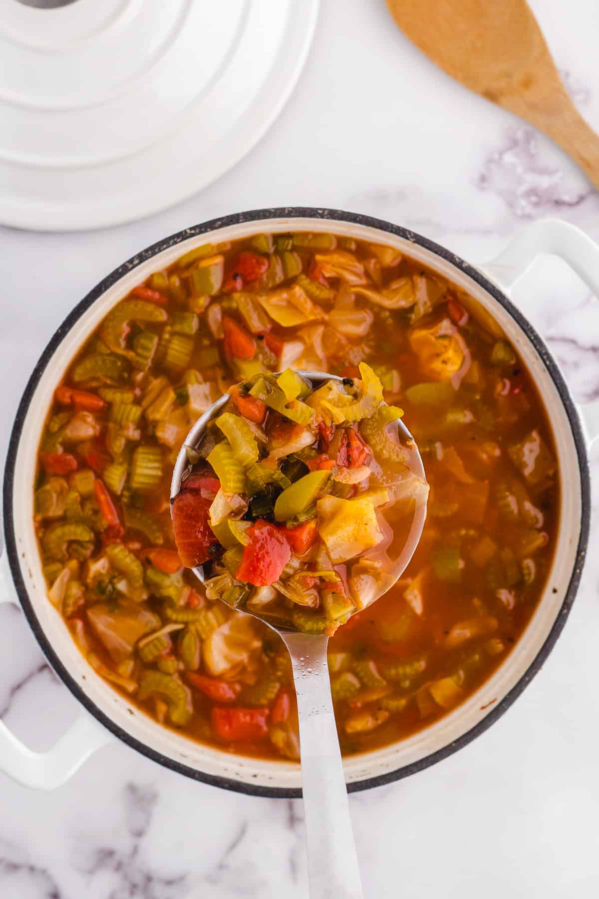 A ladle scooping out cabbage soup.