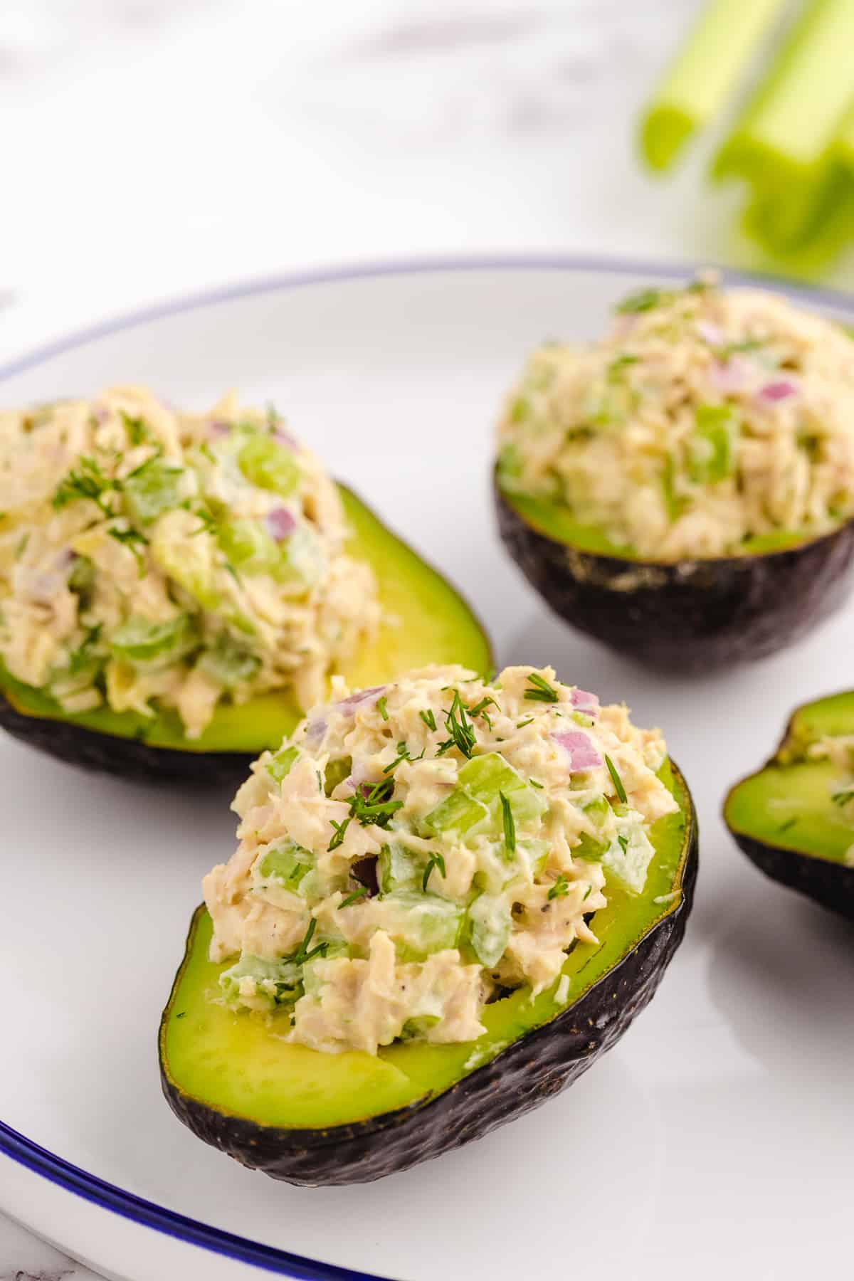 Four avocado halves filled with tuna salad.