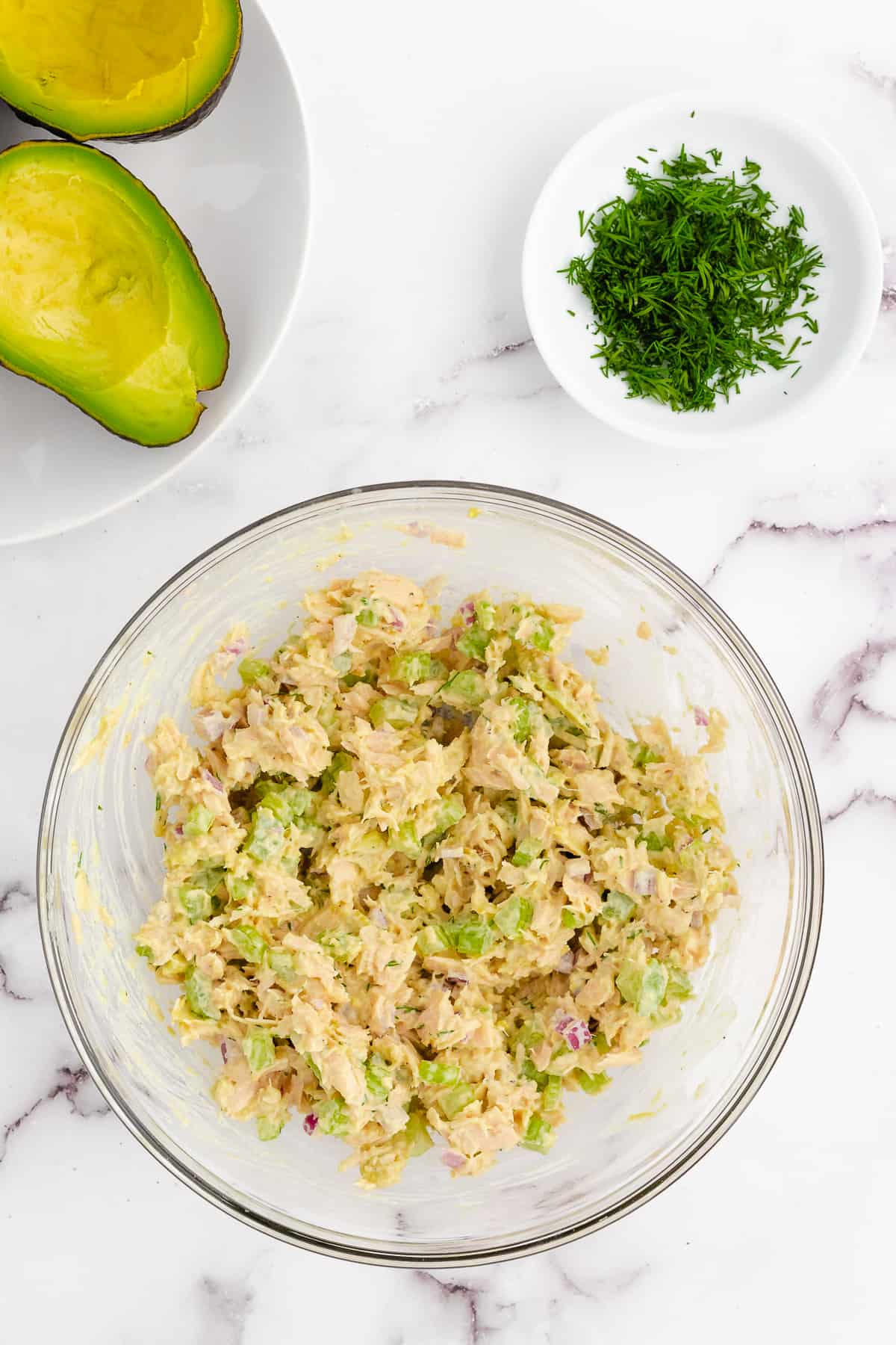 Tuna salad ingredients mixed together in a bowl.