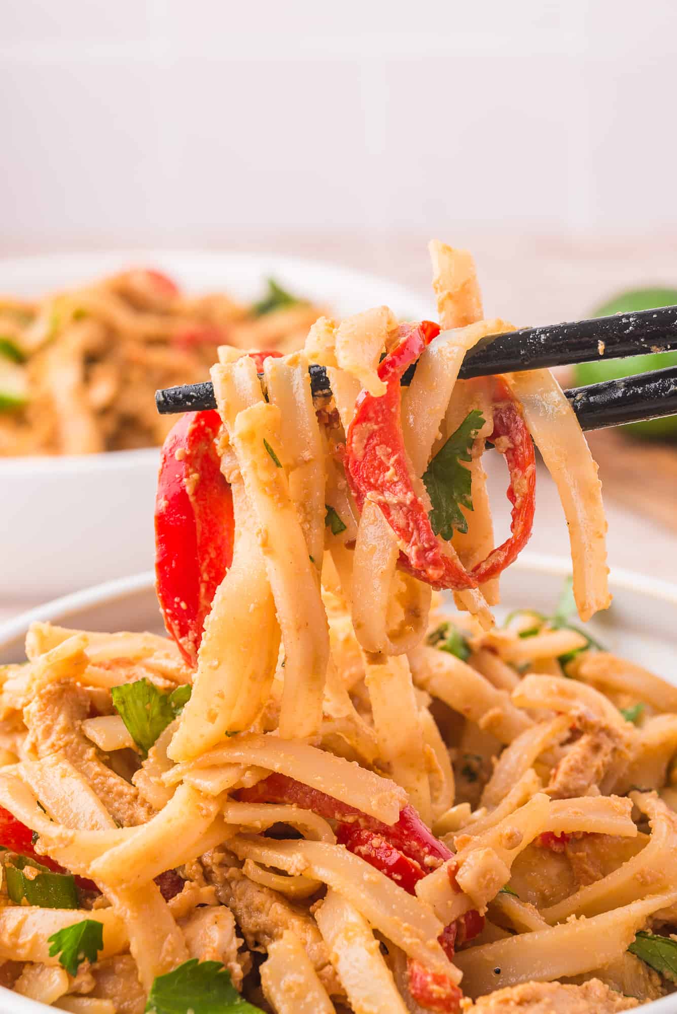 Eating the peanut noodles with chop sticks.
