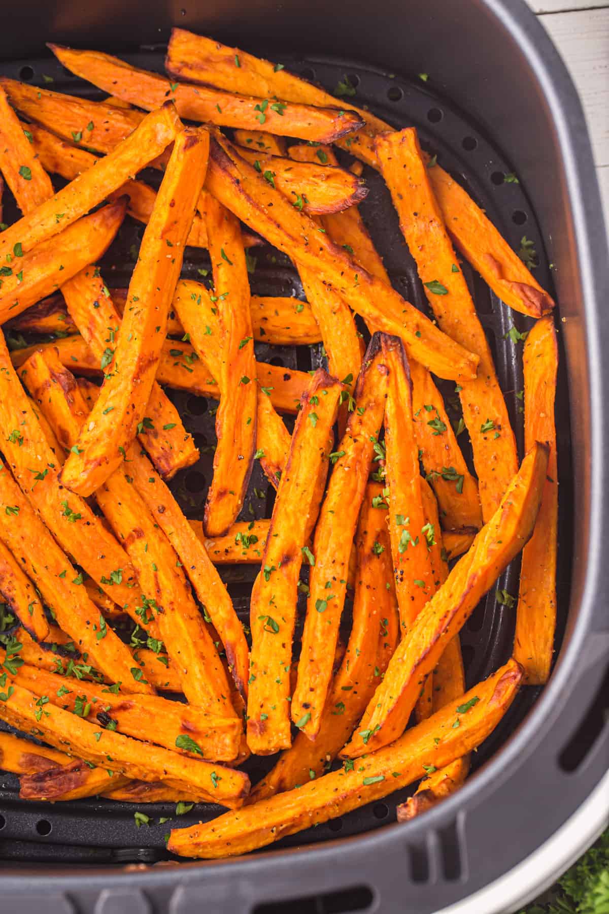 Sweet potato fries in the air fryer basket.