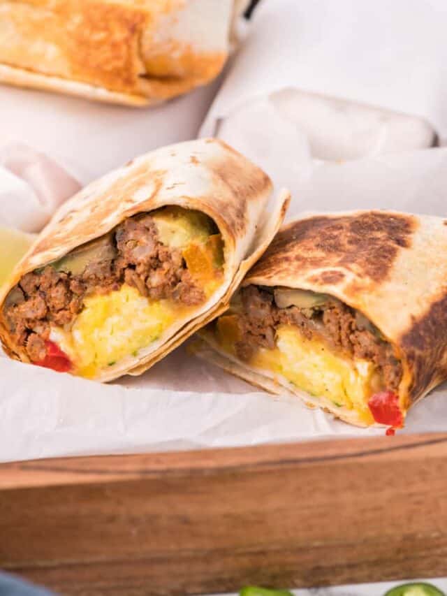 make ahead breakfast burritos cut in half showing the filling inside.