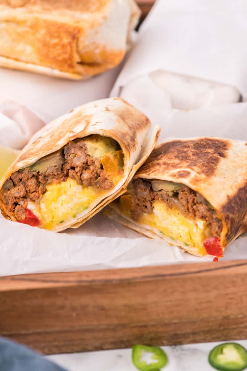 make ahead breakfast burritos cut in half showing the filling inside.