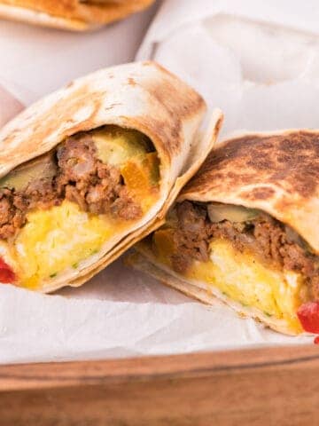 make ahead breakfast burritos cut in half showing the filling inside.