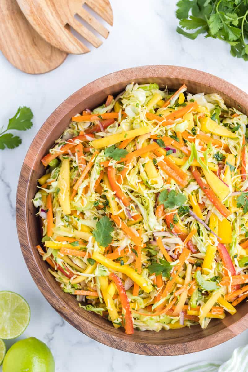 Prepared mango slaw salad in a large wooden salad bowl.
