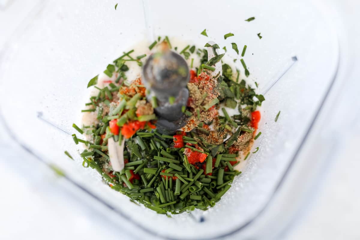 adding the spinach and roasted red pepper to the blender