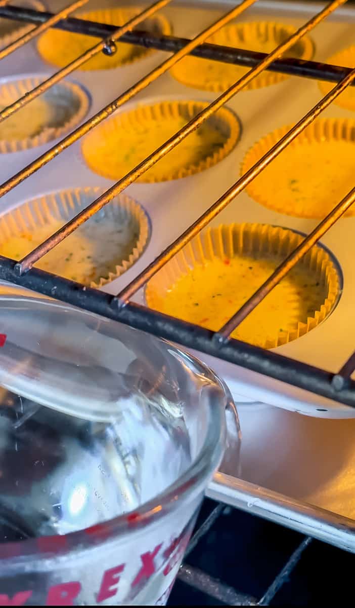 pouring water into the sheet pan to steam the egg bites
