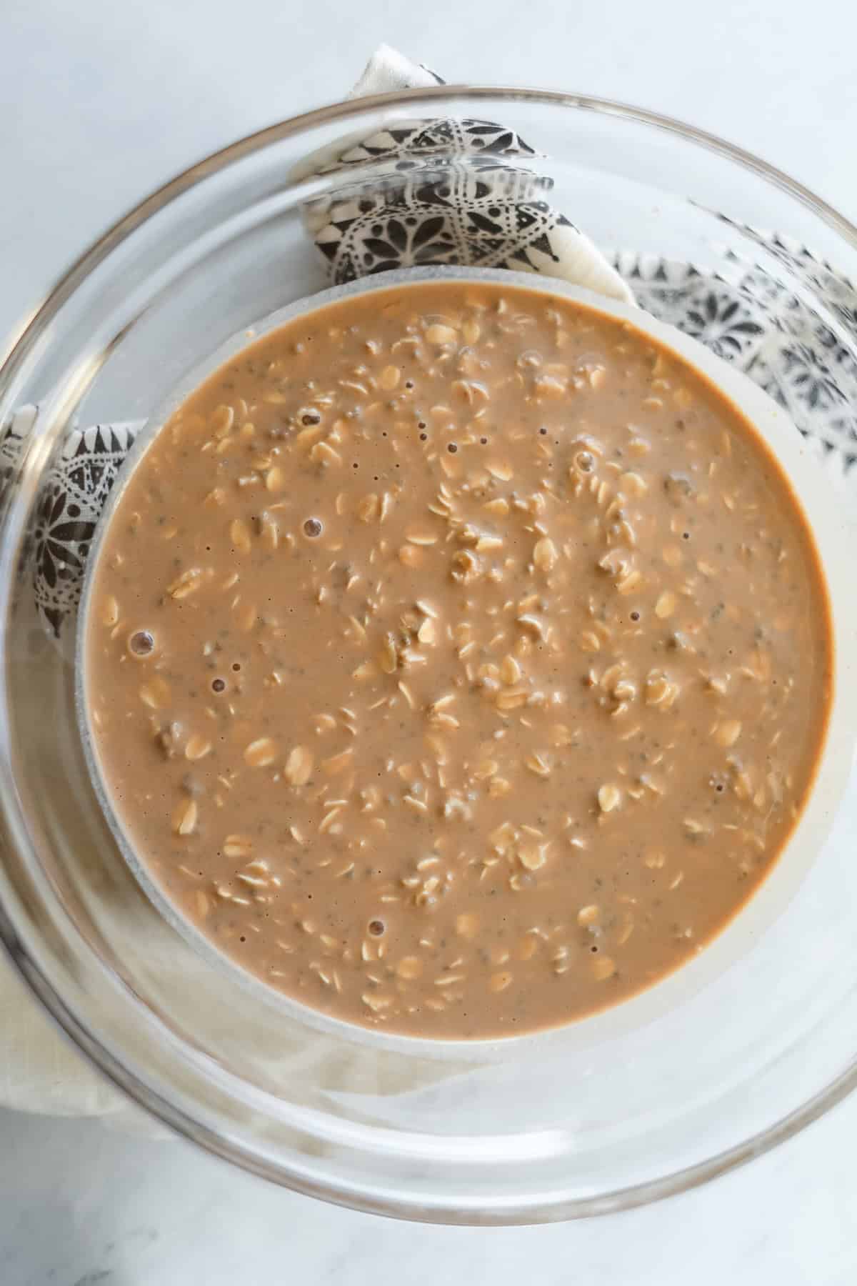 stirring the overnight oats ingredients in a clear glass mixing bowl