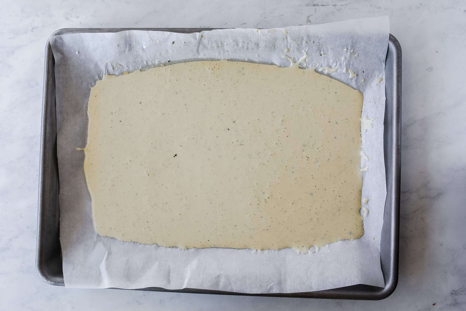 tap the sheet pan on the counter to remove bubbles and to make an even layer