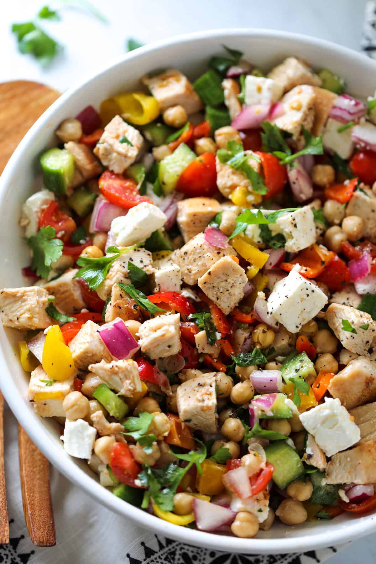 mediterranean chicken salad in a large white bowl on a white marble counter after assembling