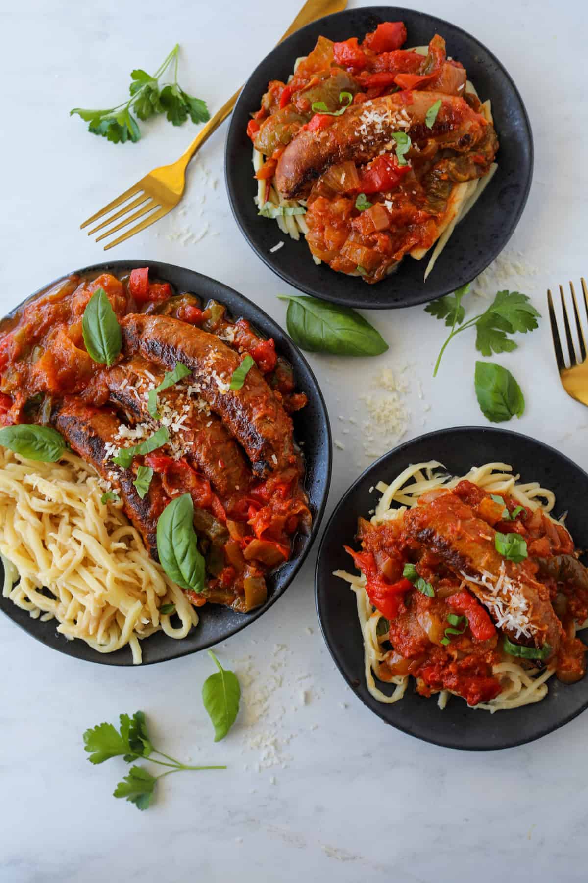 chicken sausage and peppers split between 3 plates top down view