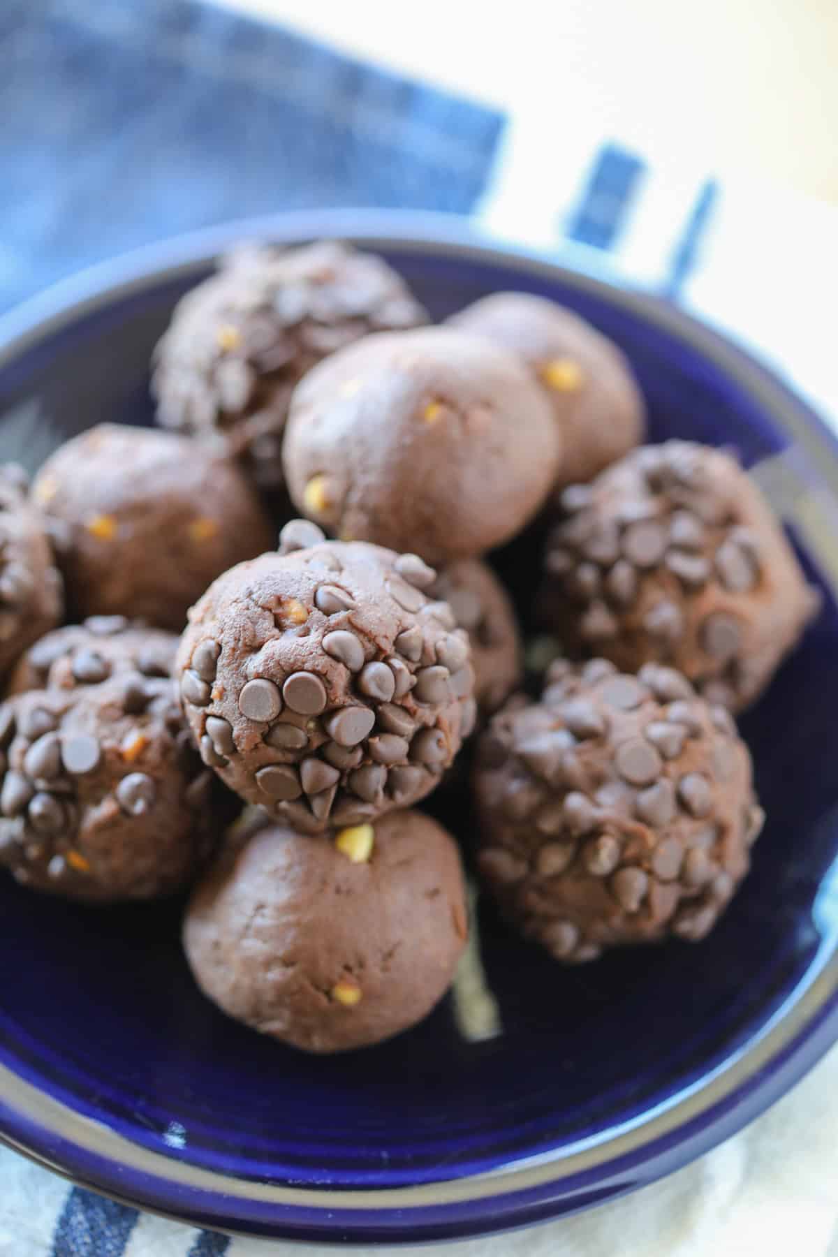 peanut butter chocolate protein balls stacked on a blue plate