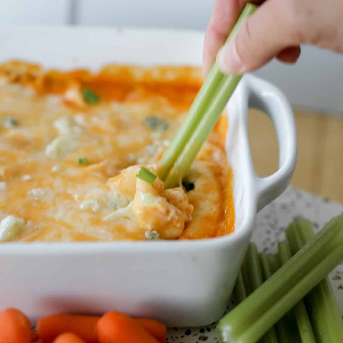 celery getting dipped into buffalo chicken dip made with cottage cheese