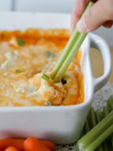 cottage cheese buffalo chicken dip with celery being used as a dipper