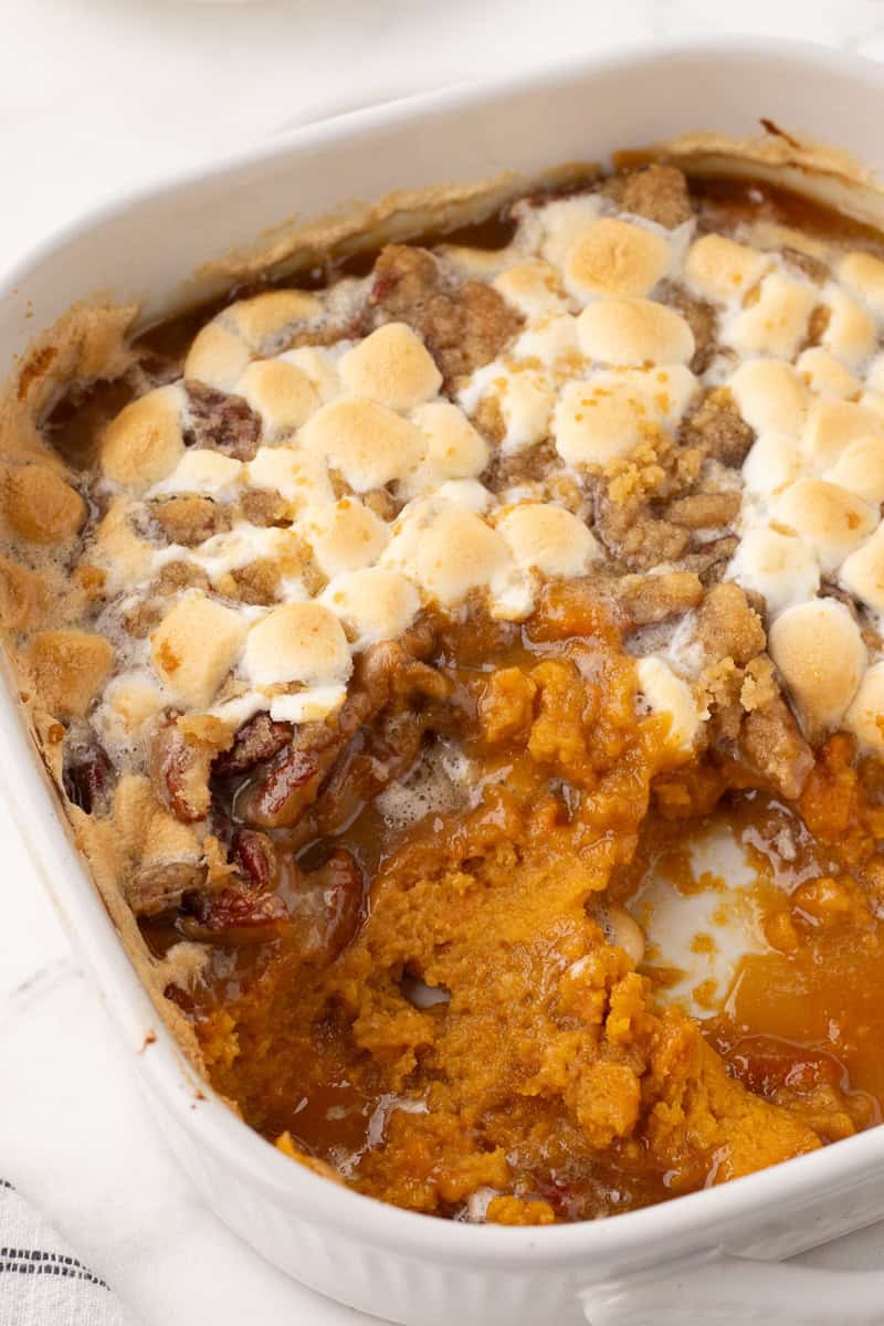 half of the pan with scooped sweet potato casserole gone 